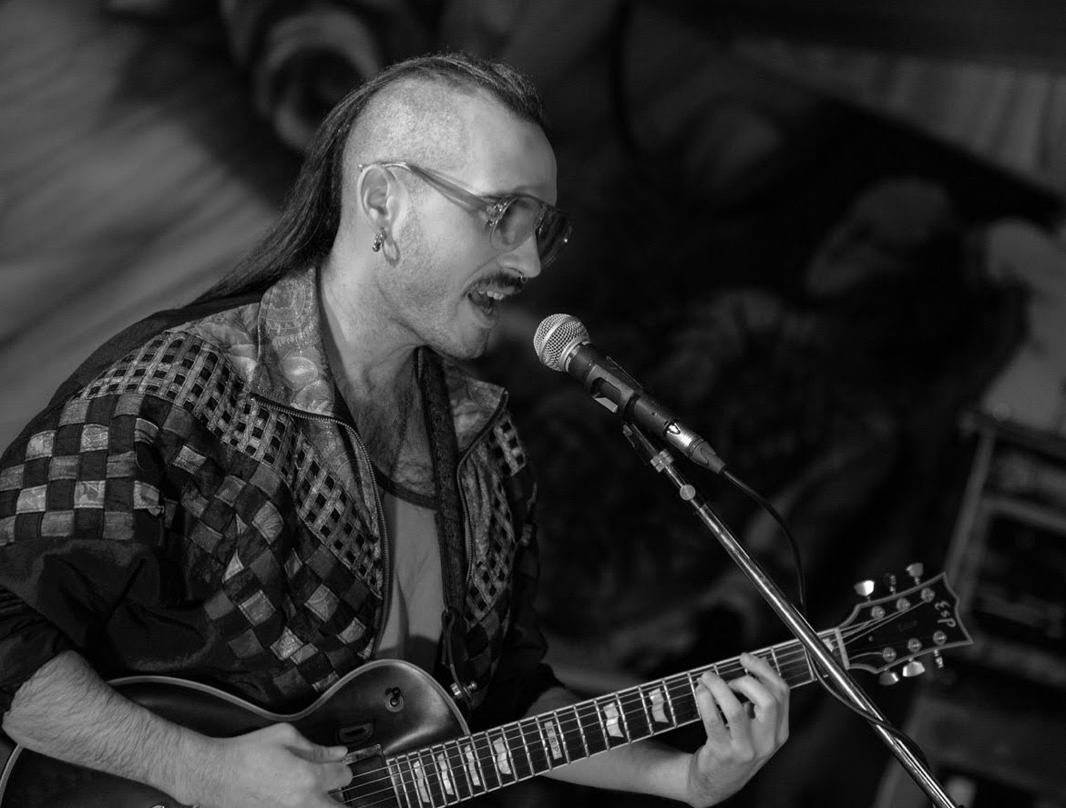 Ben Meyer singing and playing guitar in black and white