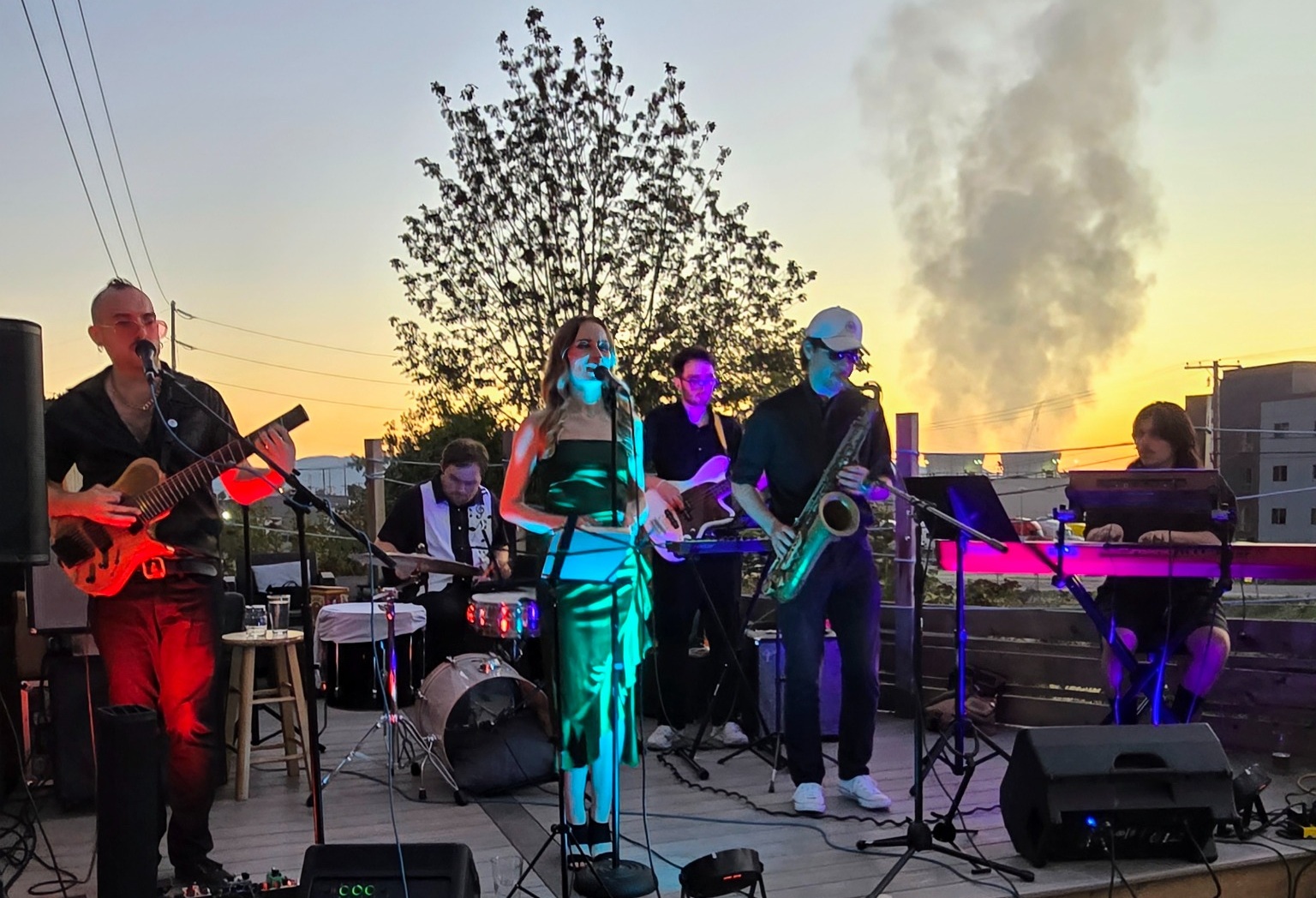 De Dream performing as a full band on a rooftop at sunset