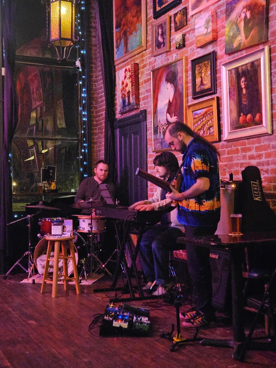 Smile Aisle trio performing in an art-filled room