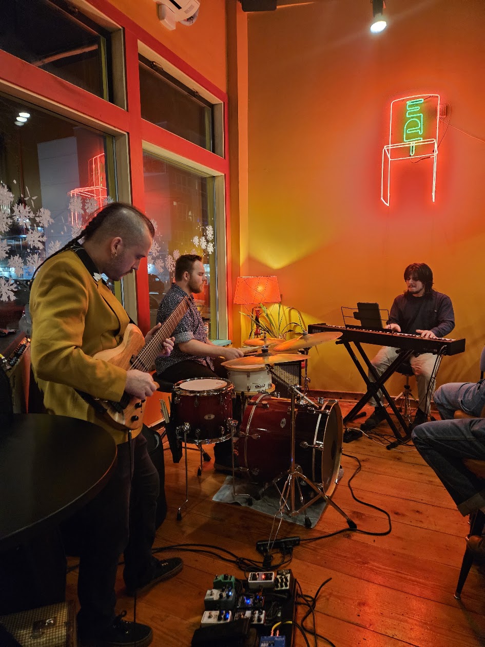 Smile Aisle trio performing in a warmly lit room