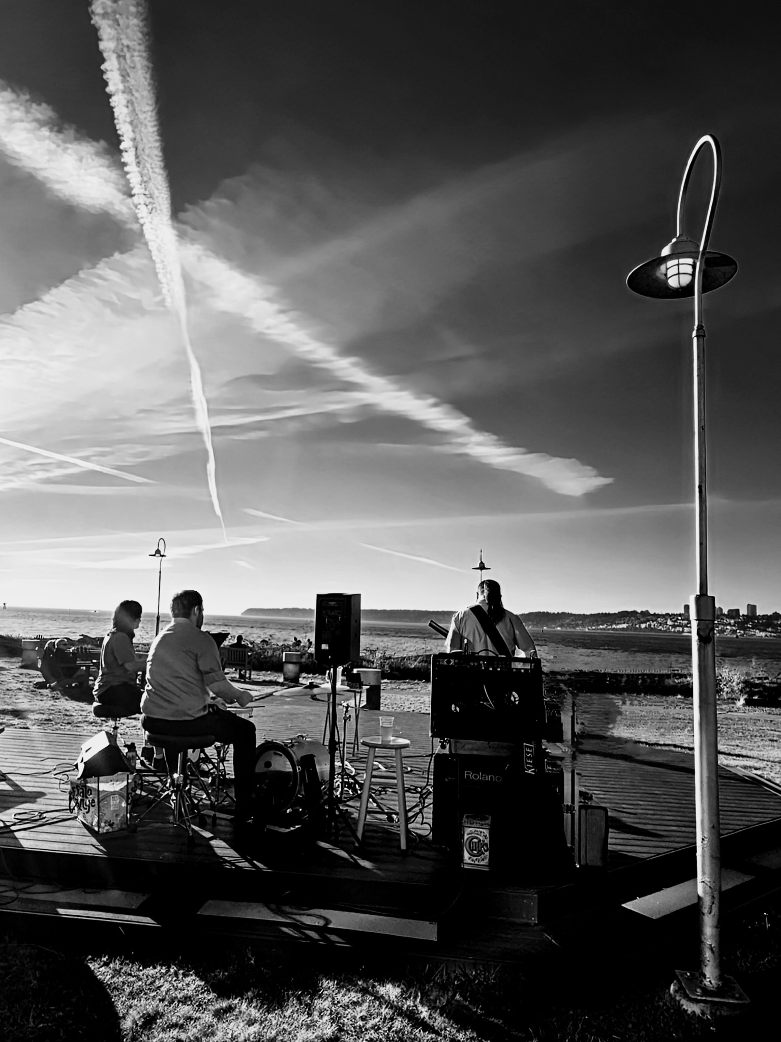 Smile Aisle trio performing by the waterfront in black and white